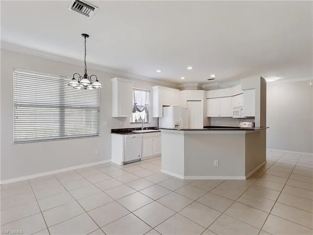 a kitchen with kitchen island granite countertop white cabinets and window