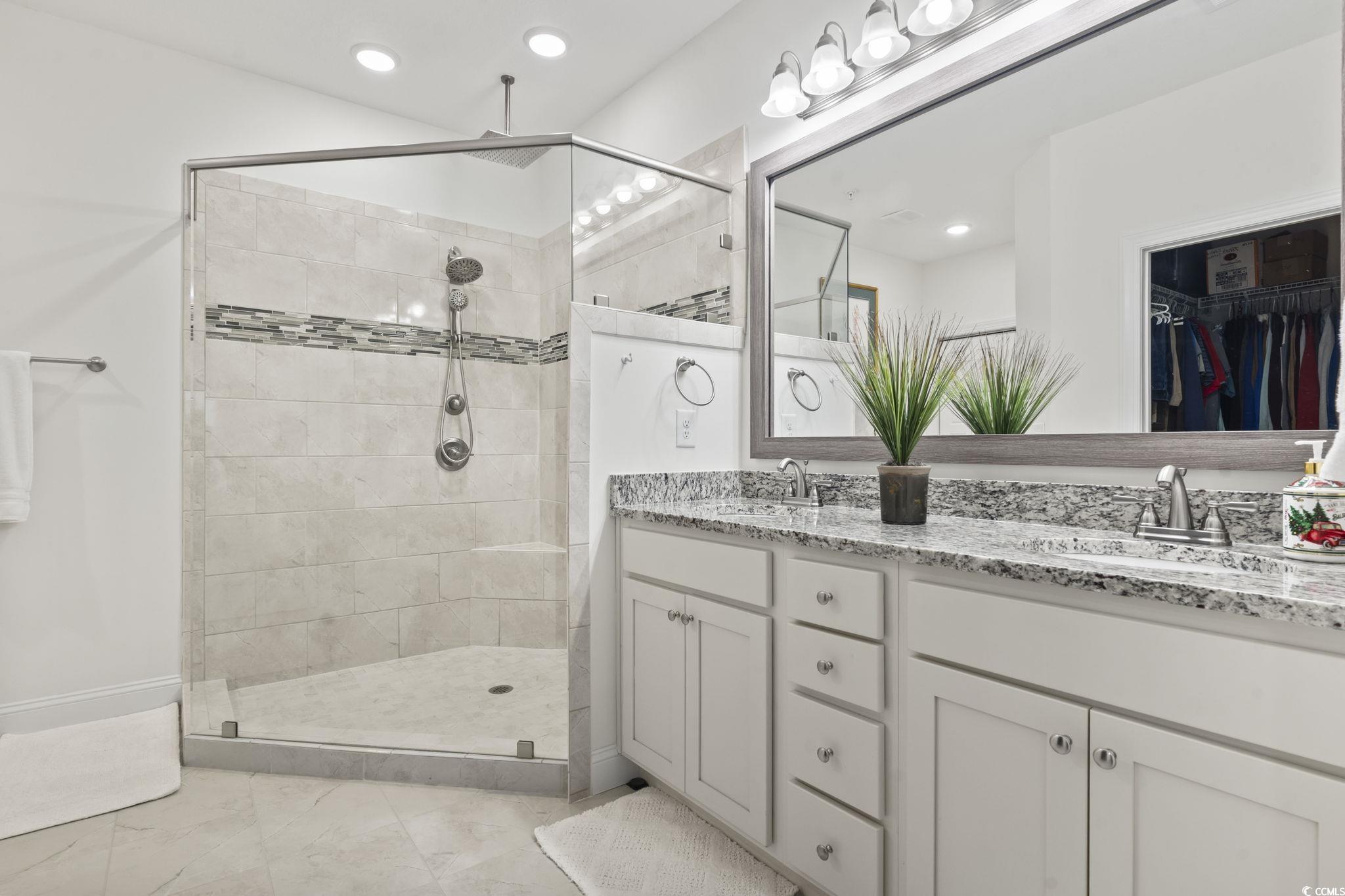 924 Jackline Place, Unit 201 Murrells Inlet, SC 29576 - Photo 30 of 35 Full bath with double vanity, a walk in shower, a spacious closet, recessed lighting, and light marble finish floors