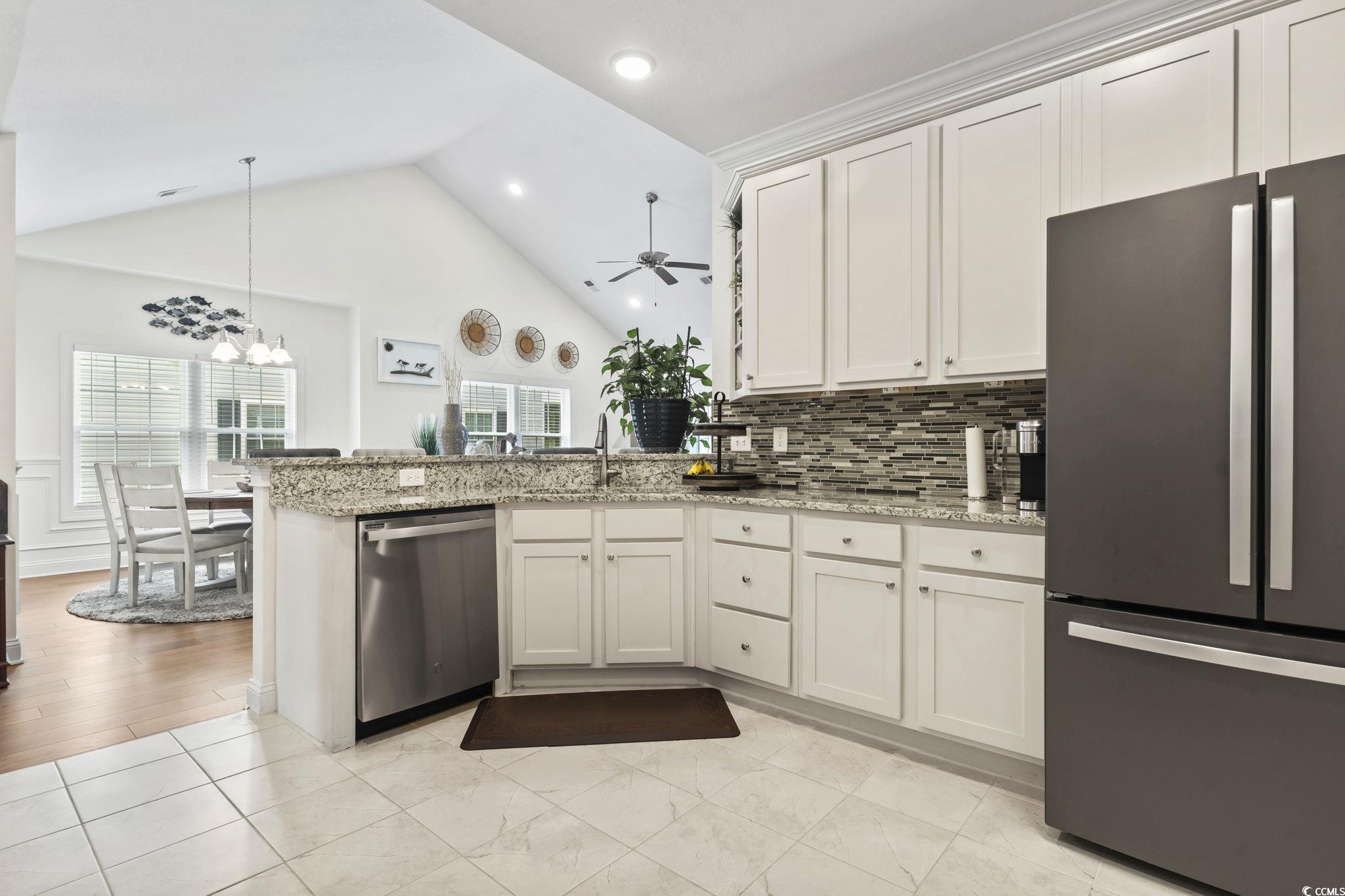 924 Jackline Place, Unit 201 Murrells Inlet, SC 29576 - Photo 5 of 35 Kitchen featuring appliances with stainless steel finishes, light stone counters, a peninsula, pendant lighting, and white cabinets