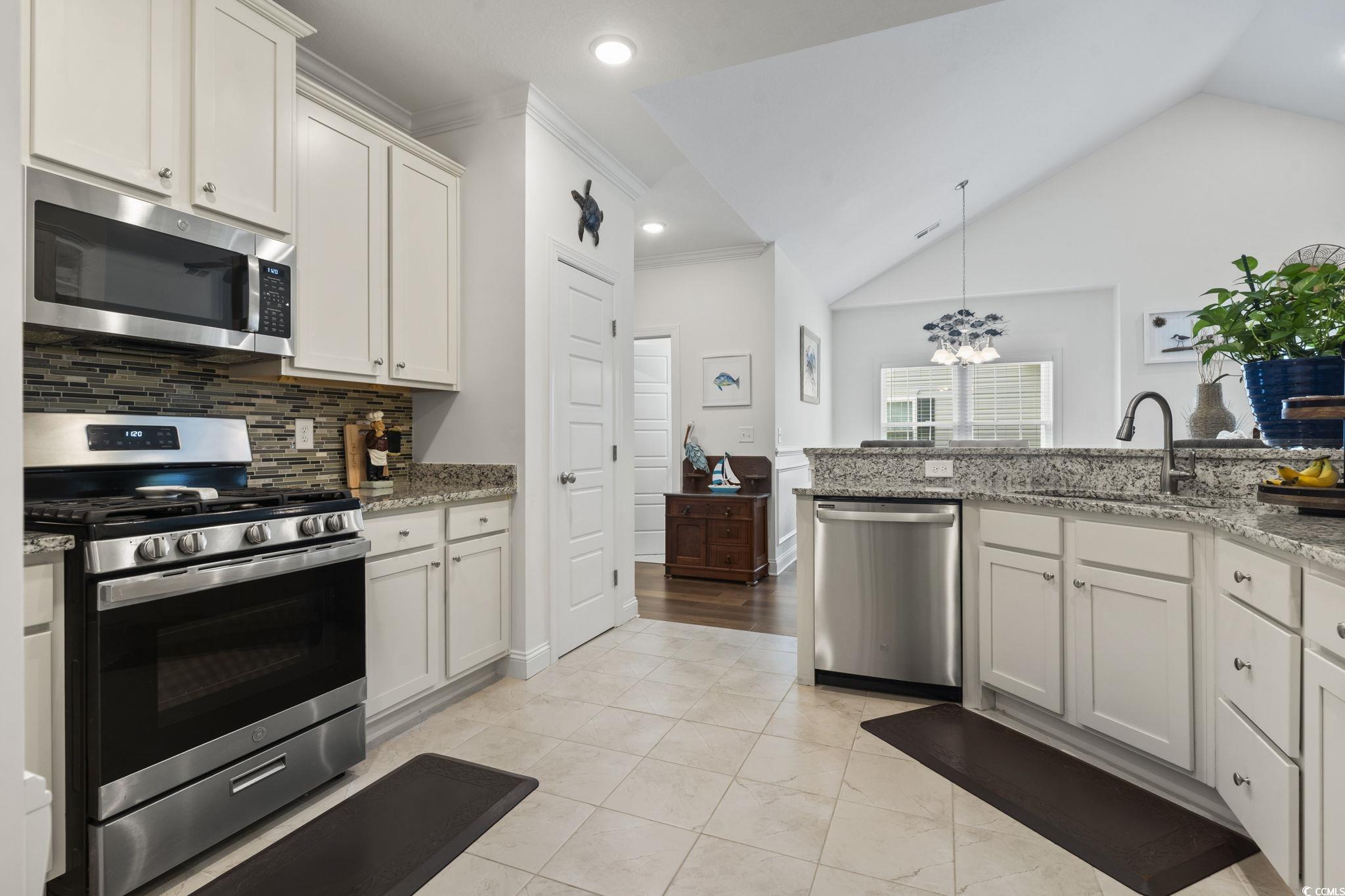 924 Jackline Place, Unit 201 Murrells Inlet, SC 29576 - Photo 6 of 35 Kitchen featuring appliances with stainless steel finishes, a chandelier, light stone counters, decorative light fixtures, and white cabinetry