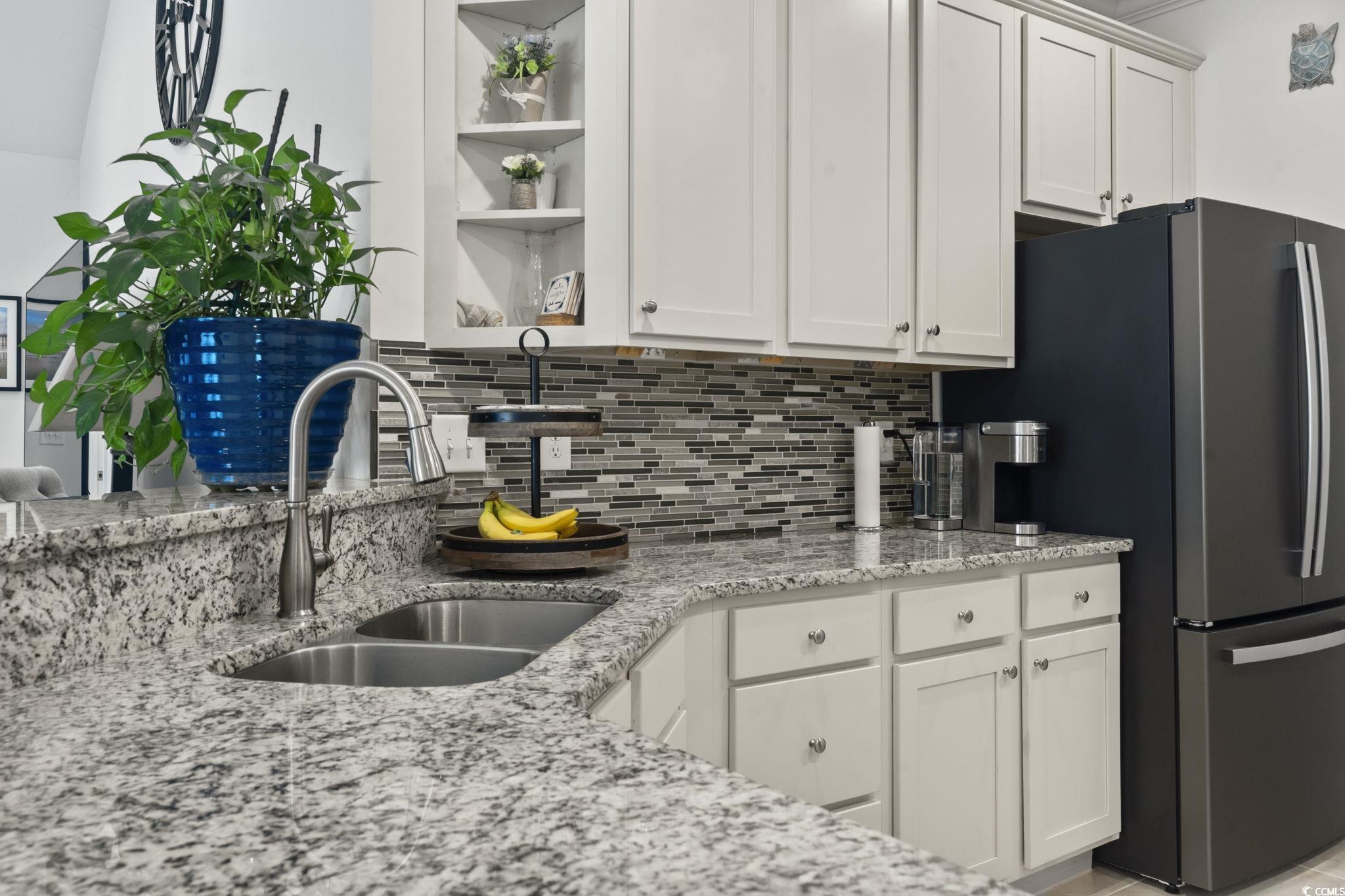 924 Jackline Place, Unit 201 Murrells Inlet, SC 29576 - Photo 9 of 35 Kitchen featuring open shelves, light stone countertops, white cabinets, tasteful backsplash, and freestanding refrigerator