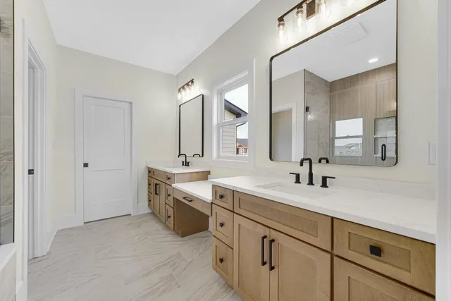 a spacious bathroom with a double vanity sink and mirror