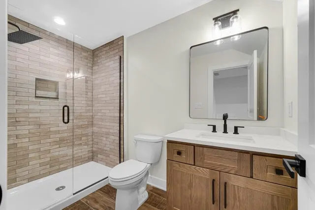 a bathroom with a sink a toilet and shower