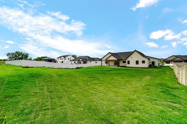 a view of a house with a big yard and large trees