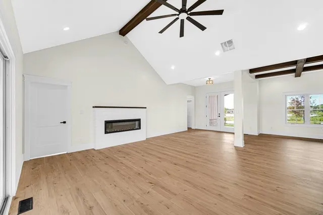 a view of empty room with wooden floor and window