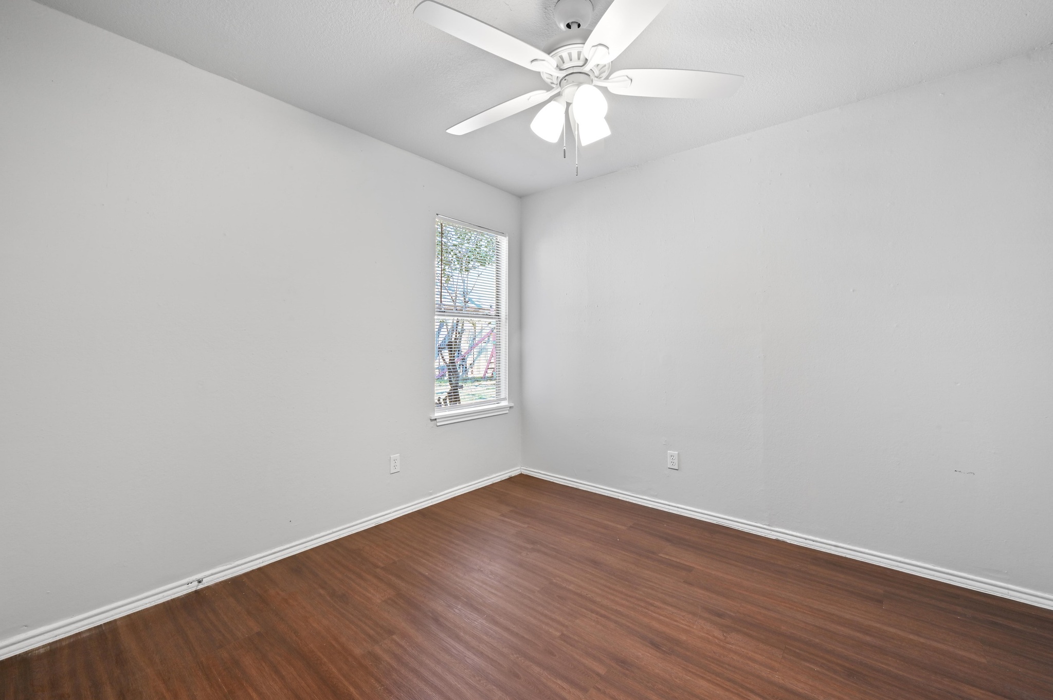 5303 Spring Meadow Road Austin, TX 78744 - Photo 17 of 20 an empty room with wooden floor fan and windows