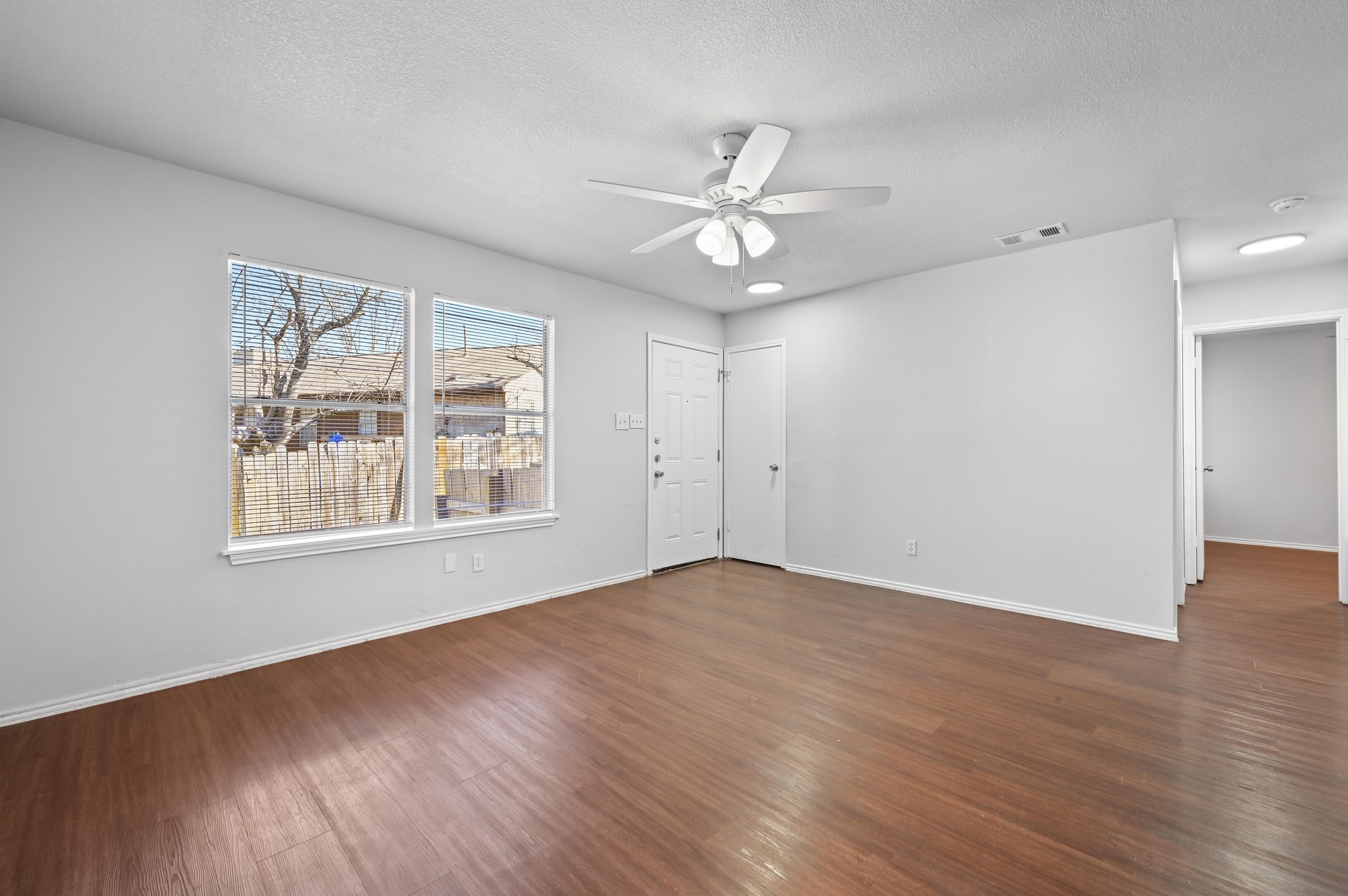5303 Spring Meadow Road Austin, TX 78744 - Photo 7 of 20 a view of an empty room with wooden floor and a window