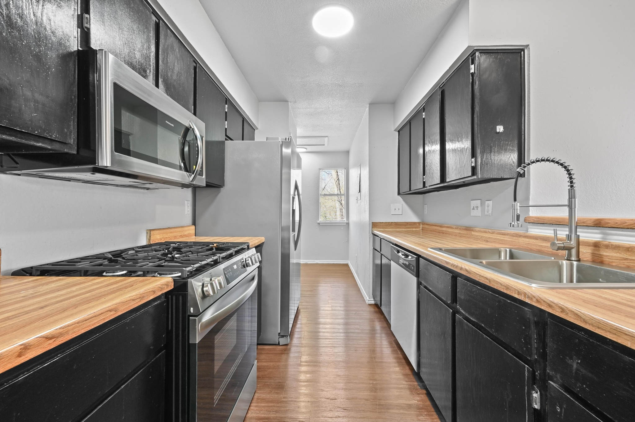 5303 Spring Meadow Road Austin, TX 78744 - Photo 9 of 20 a kitchen with stainless steel appliances granite countertop a sink stove and cabinets
