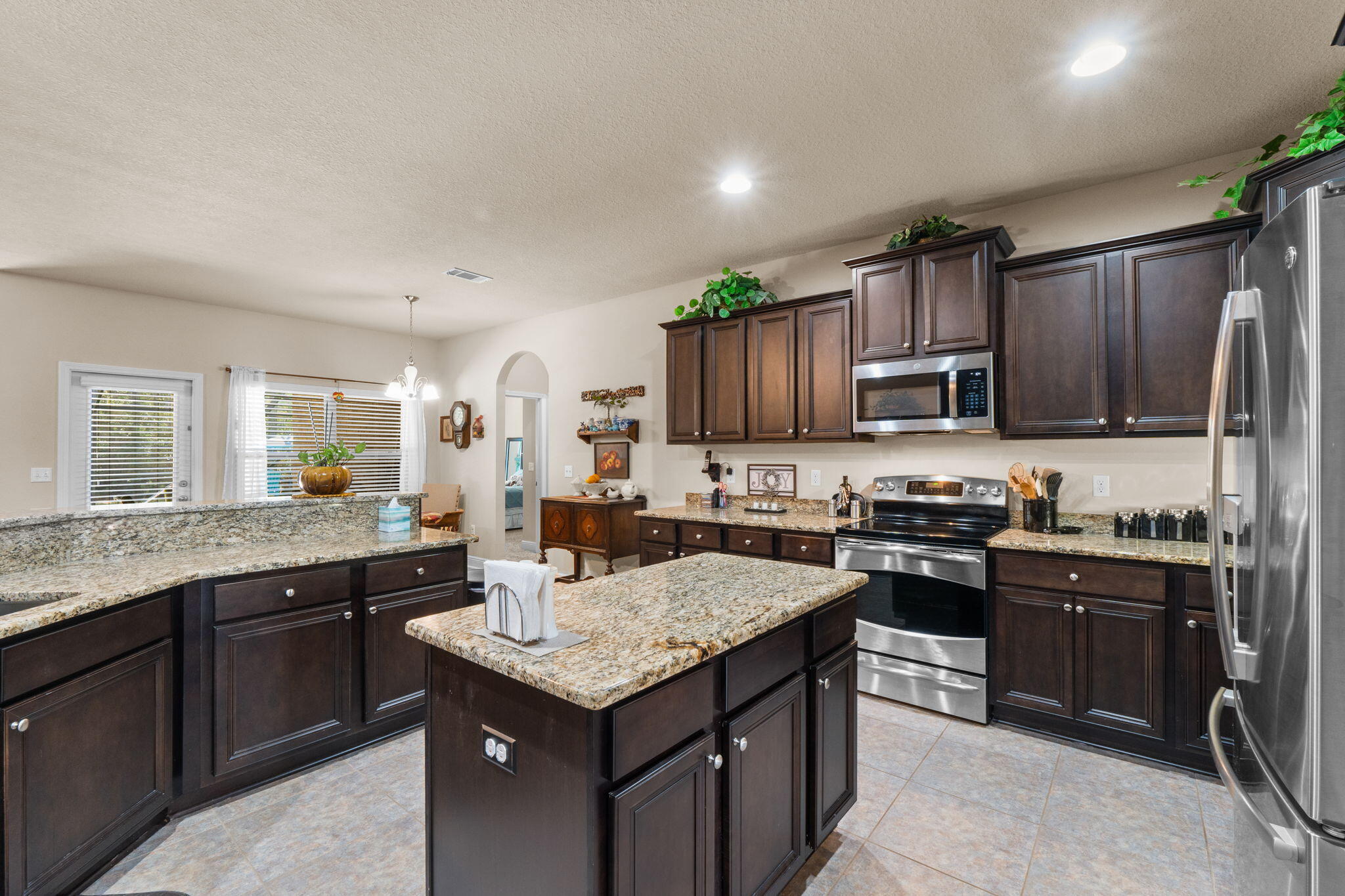 67 Secret Street Freeport, FL 32439 - Photo 20 of 63 a kitchen with granite countertop stainless steel appliances a sink dishwasher a stove refrigerator and cabinets