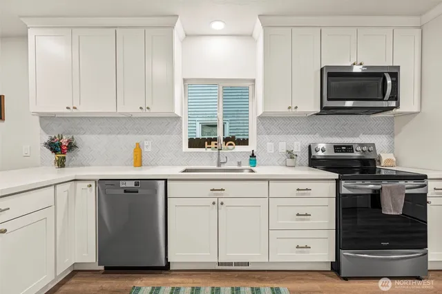 a kitchen with white cabinets stainless steel appliances and sink