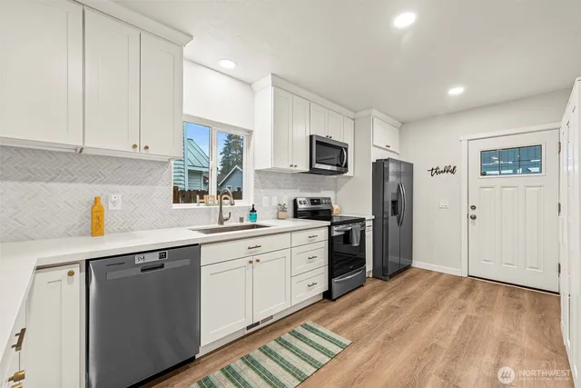 a kitchen with stainless steel appliances a refrigerator stove microwave and sink