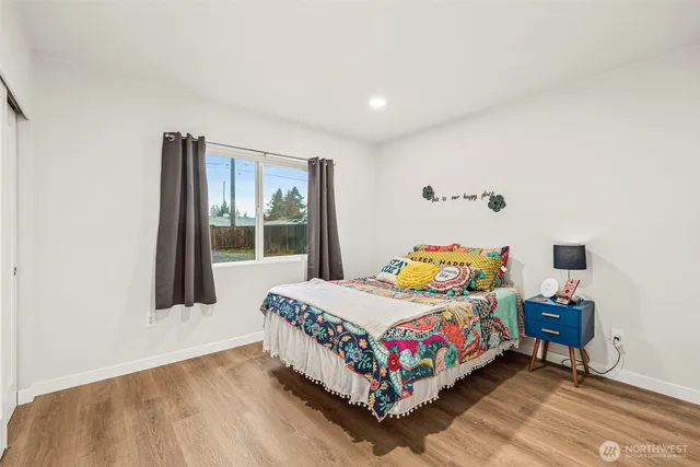 a bedroom with a bed table and a window