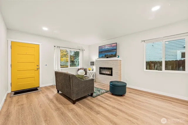 a living room with furniture a flat screen tv and a fireplace