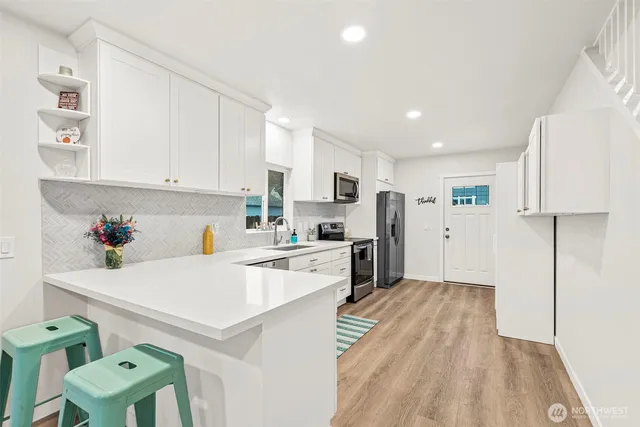 a kitchen with white cabinets and stainless steel appliances