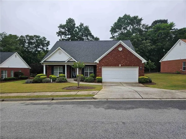 a front view of a house with a yard and trees