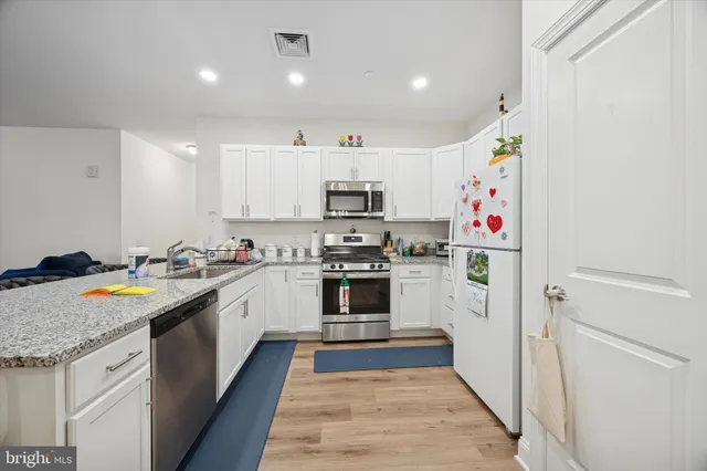 a kitchen with granite countertop a white stove top oven and sink