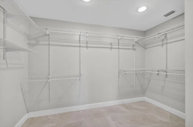 a view of a big room with wooden floor and windows