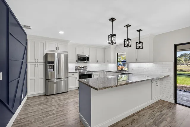 a kitchen with stainless steel appliances granite countertop a sink stove and refrigerator