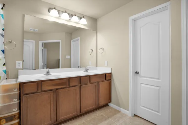a bathroom with a double vanity sink and a mirror
