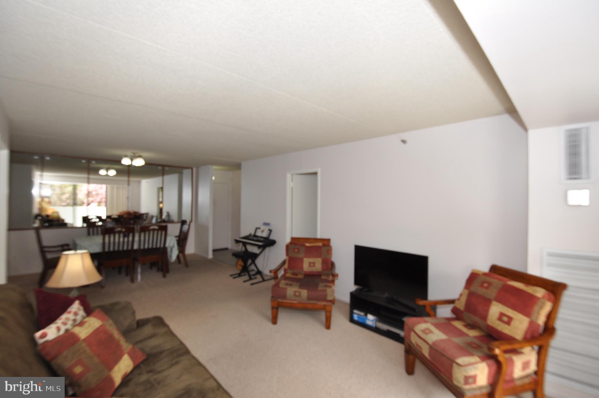 5911 Edsall Road, Unit 403 Alexandria, VA 22304 - Photo 10 of 29 a living room with furniture and a flat screen tv