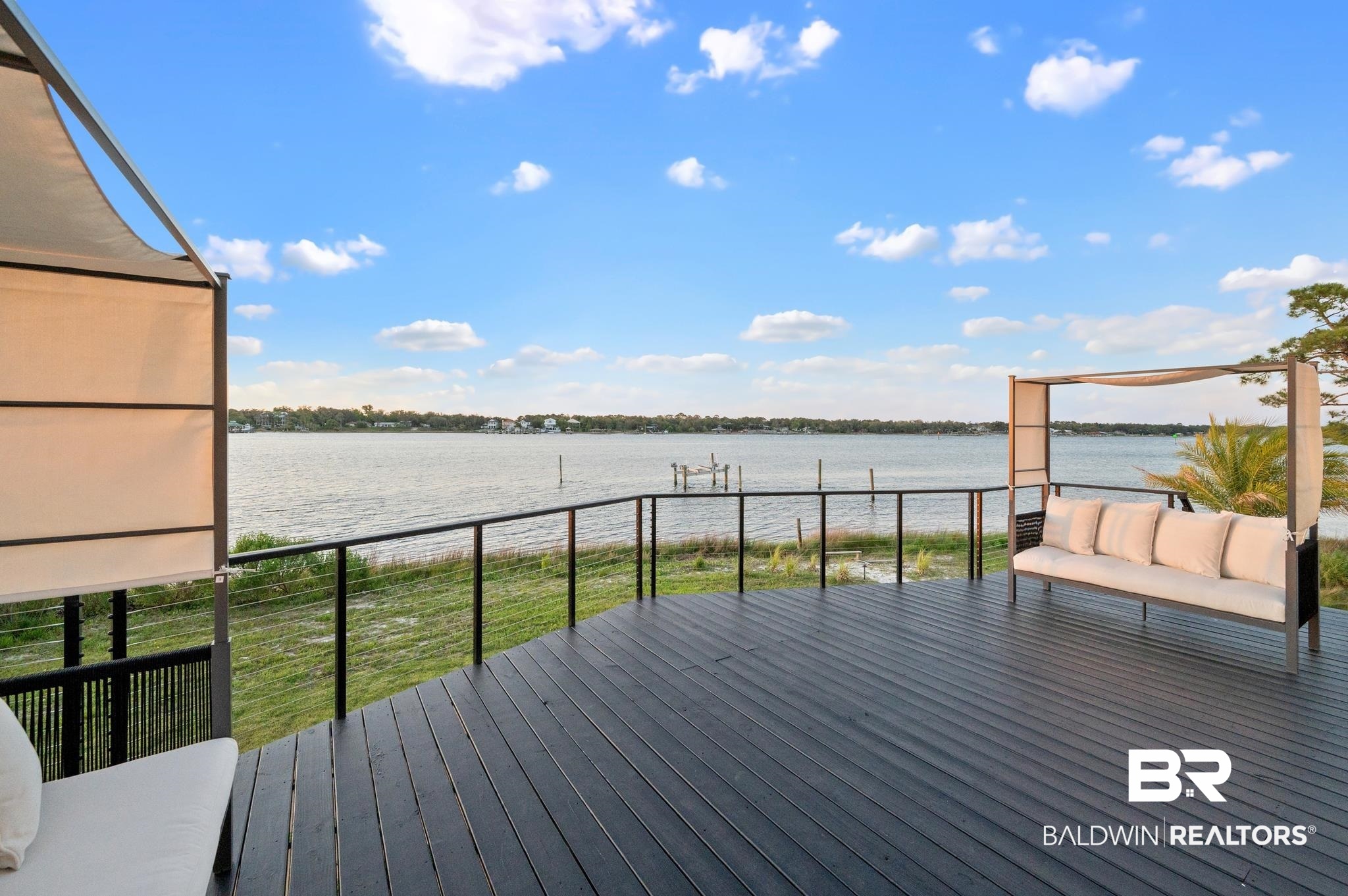 33349 River Road Orange Beach, AL 36561 - Photo 6 of 61 Expansive waterfront deck featuring dark composite decking and cable railing