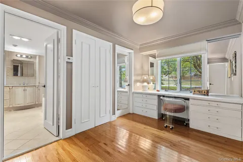 a view of a workspace with furniture and a window