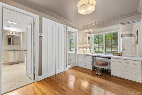 a view of a workspace with furniture and a window