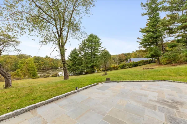 a backyard of a house with a yard and large trees