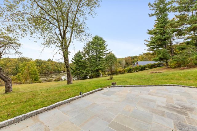 a backyard of a house with a yard and large trees