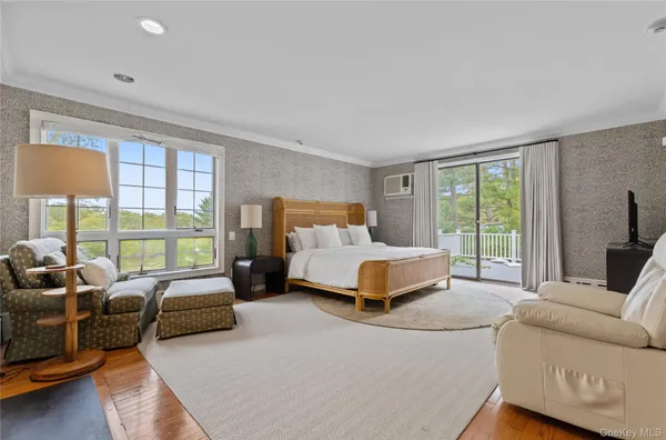 a bedroom with furniture and large windows