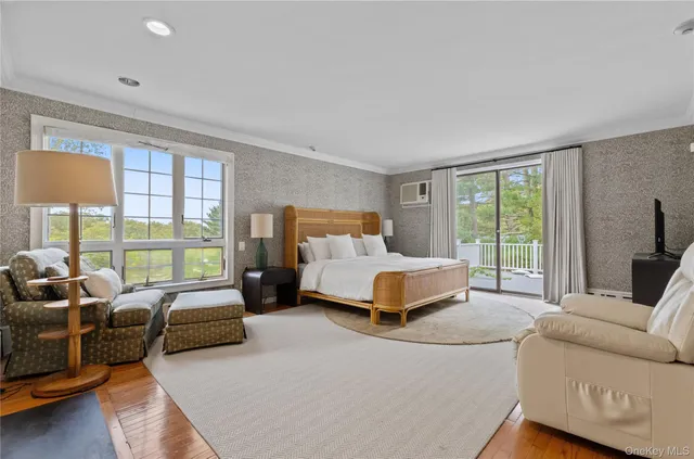a bedroom with furniture and large windows