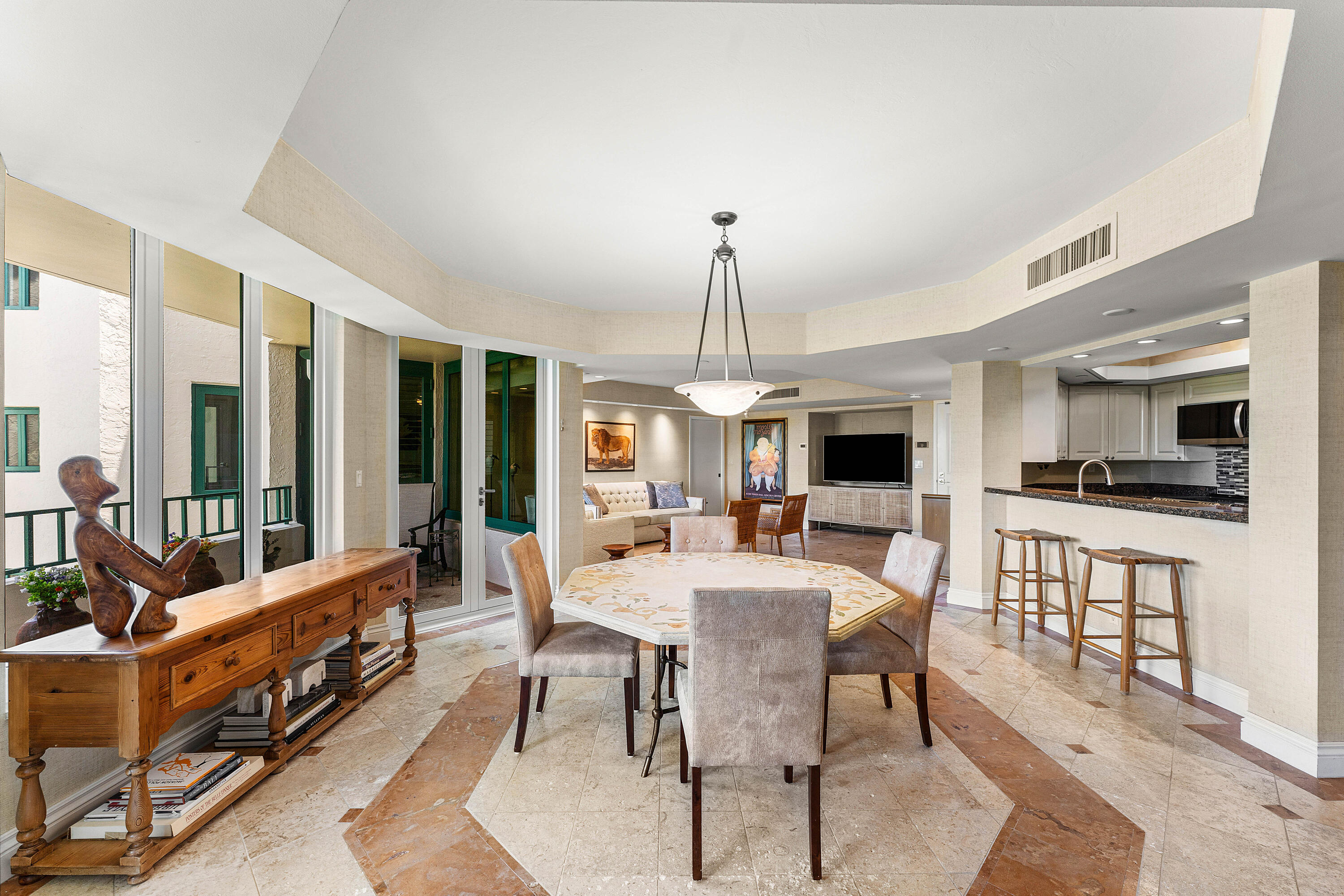 100 Southeast 5th Avenue, Unit 410 Boca Raton, FL 33432 - Photo 11 of 63 a view of a dining room and livingroom with furniture wooden floor a rug a flat screen tv a rug and a chandelier