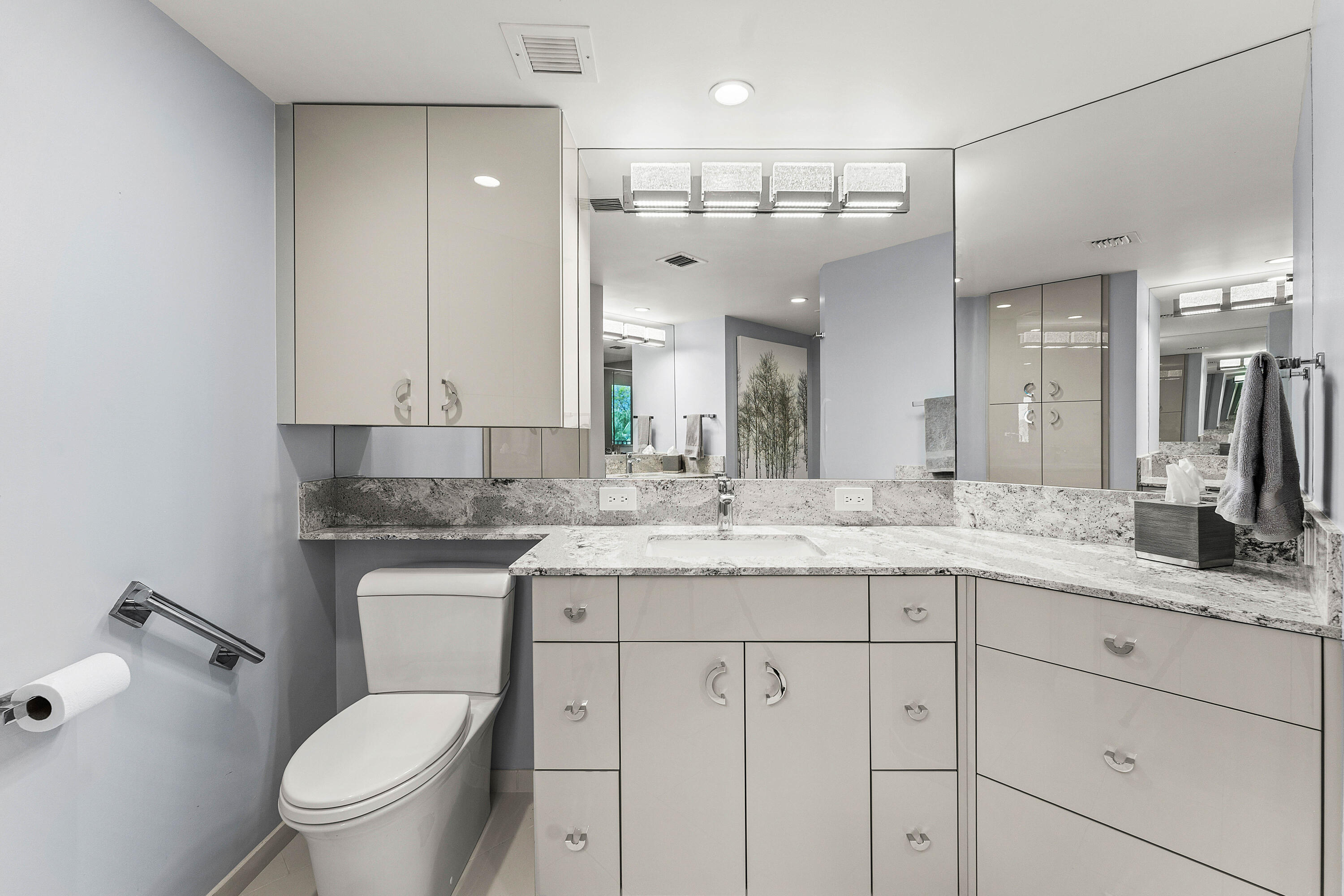 100 Southeast 5th Avenue, Unit 410 Boca Raton, FL 33432 - Photo 25 of 63 a bathroom with a granite countertop sink a toilet a mirror and vanity