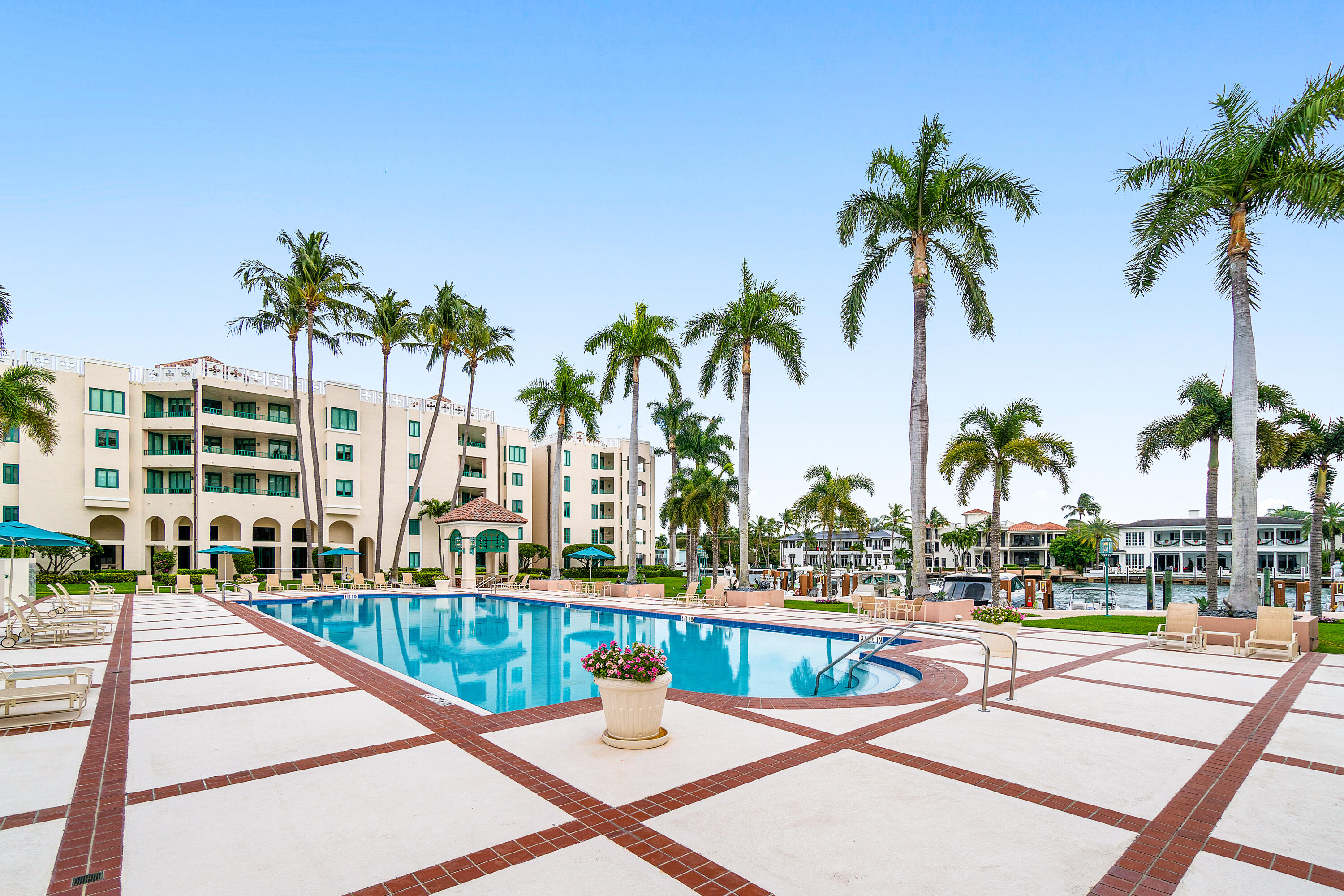 100 Southeast 5th Avenue, Unit 410 Boca Raton, FL 33432 - Photo 58 of 63 a view of a swimming pool with a lawn chairs and palm tree