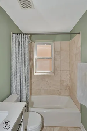 a bathroom with a granite countertop bathtub shower sink vanity and toilet