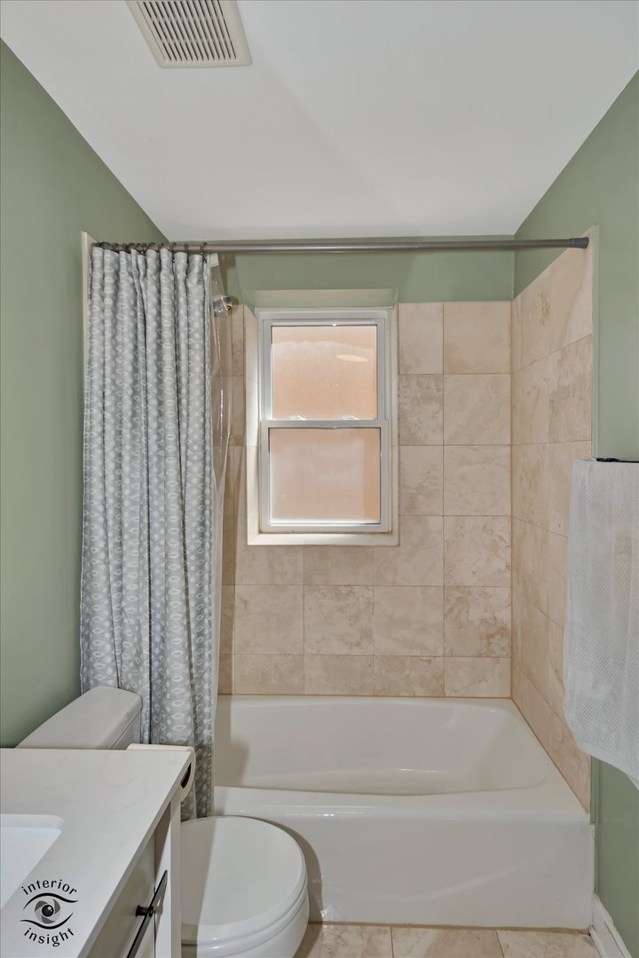 2537 Prairie Avenue, Unit 2E Evanston, IL 60201 - Photo 16 of 21 a bathroom with a granite countertop bathtub shower sink vanity and toilet
