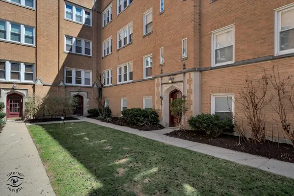 a front view of a residential apartment building with a yard