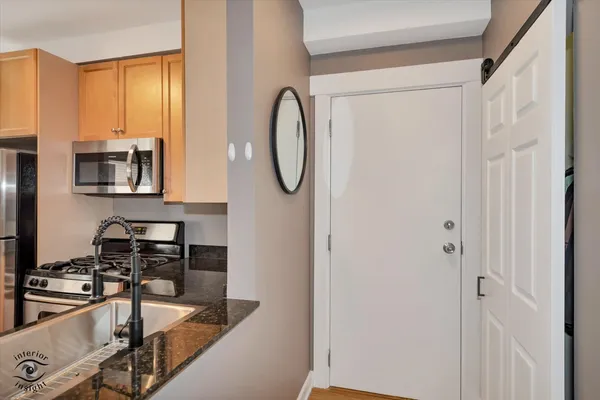 a kitchen with stainless steel appliances granite countertop a sink and a refrigerator