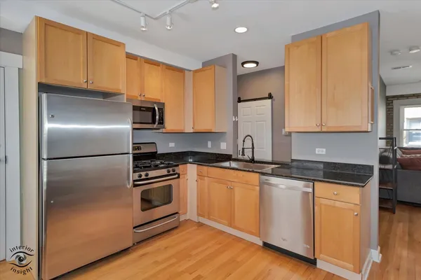 a kitchen with a refrigerator sink and cabinets