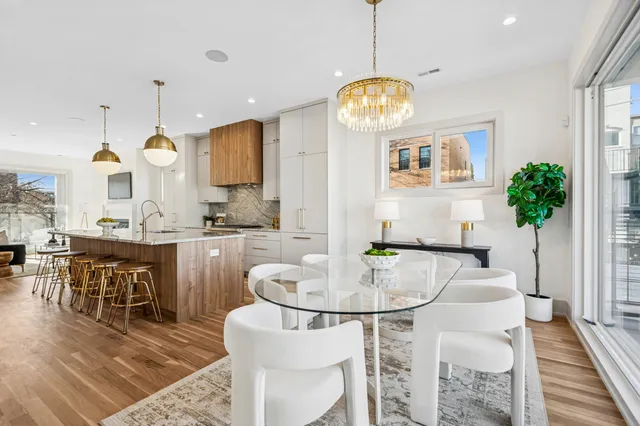 a very nice looking dining room with kitchen island furniture a chandelier and a view of kitchen