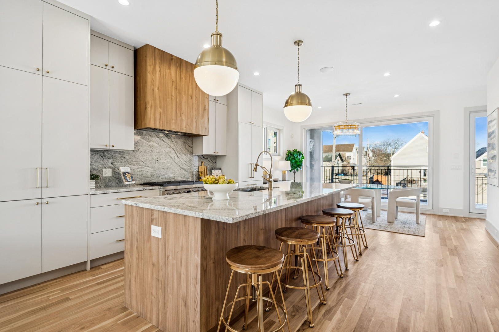2246 West Lyndale Street, Unit 2 Chicago, IL 60647 - Photo 3 of 27 a kitchen with stainless steel appliances kitchen island granite countertop a stove a sink a dining table and chairs with wooden floor