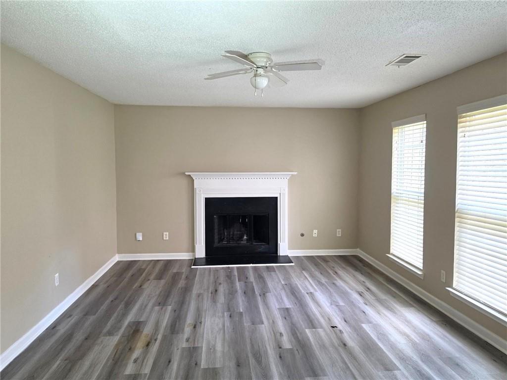 92 Revere Turn Fairburn, GA 30213 - Photo 14 of 42 wooden floor fireplace and windows in an empty room