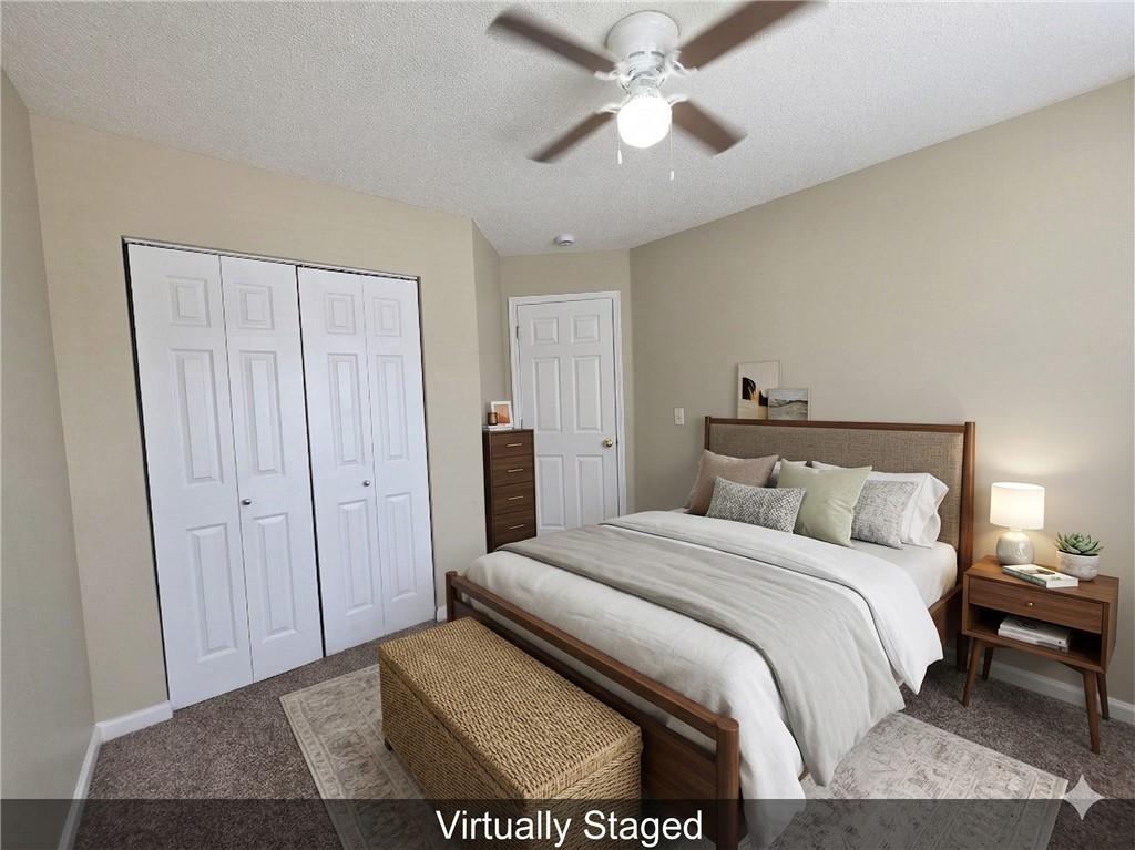 92 Revere Turn Fairburn, GA 30213 - Photo 25 of 42 a bedroom with a large bed and a chandelier