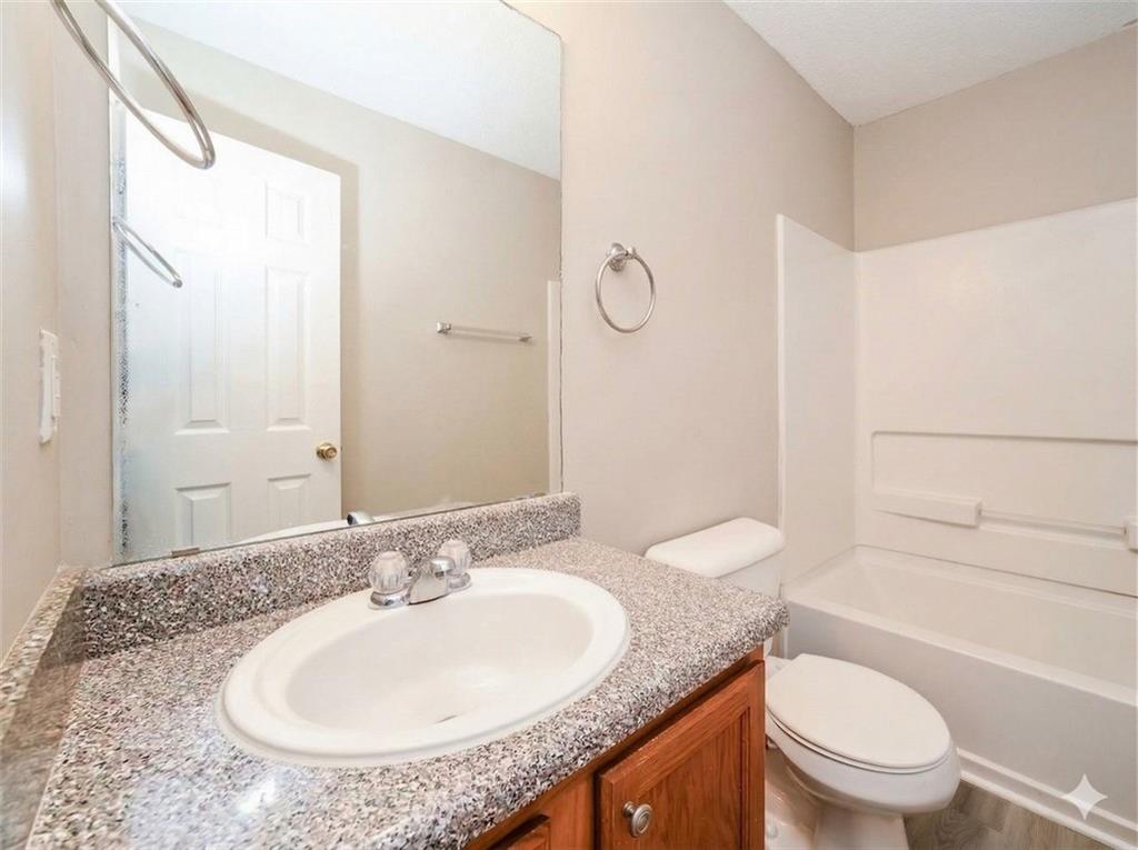 92 Revere Turn Fairburn, GA 30213 - Photo 30 of 42 a bathroom with a granite countertop sink toilet and shower