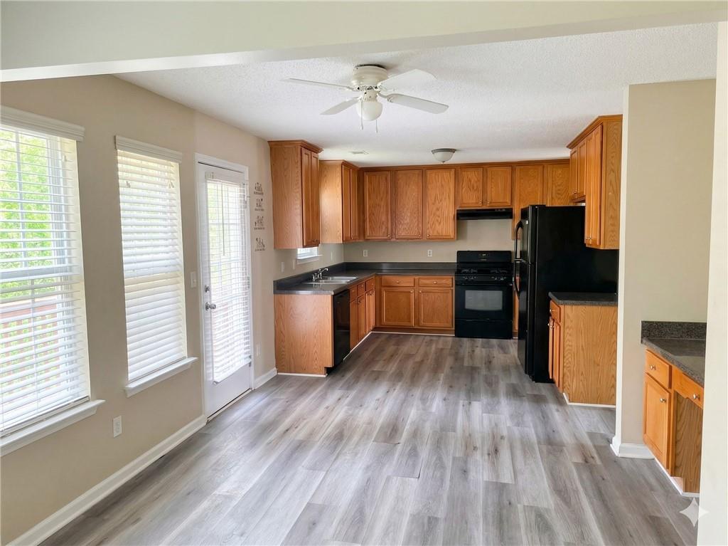 92 Revere Turn Fairburn, GA 30213 - Photo 6 of 42 a kitchen with wooden floors and refrigerator