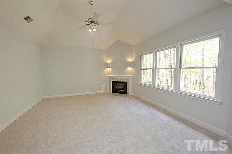 12317 Glenlivet Way Raleigh, NC 27613 - Photo 14 of 25 an empty room with windows and fireplace
