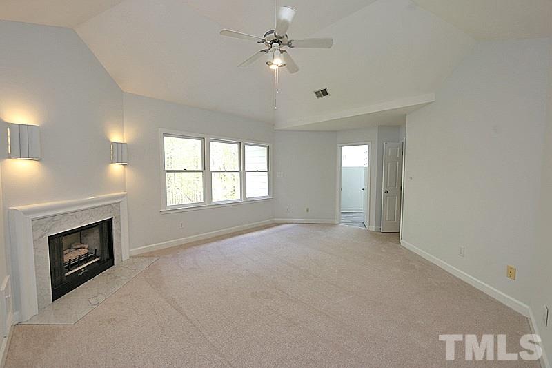 12317 Glenlivet Way Raleigh, NC 27613 - Photo 15 of 25 a view of an empty room with a fireplace and a window