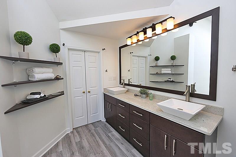 12317 Glenlivet Way Raleigh, NC 27613 - Photo 16 of 25 a bathroom with a sink a mirror and shower