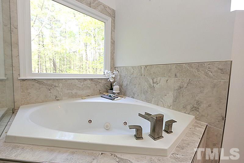 12317 Glenlivet Way Raleigh, NC 27613 - Photo 18 of 25 a bathroom with a bathtub