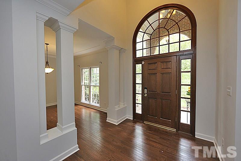 12317 Glenlivet Way Raleigh, NC 27613 - Photo 3 of 25 an empty room with wooden floor cabinet and windows